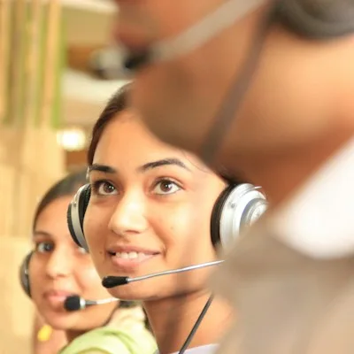 Dos personas con auriculares en una oficina luminosa